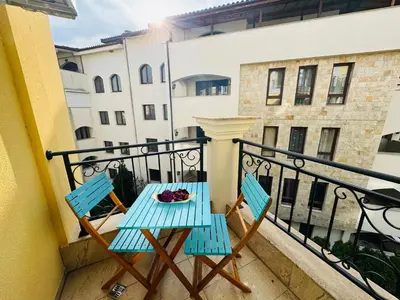 a balcony with two chairs and a plate of food at HORIZON 34 'Б-' Apartment Sveti Vlas in Sveti Vlas