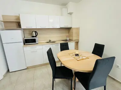 a small kitchen with a wooden table and chairs at HORIZON 31 'Б' Apartment Sveti Vlas in Sveti Vlas