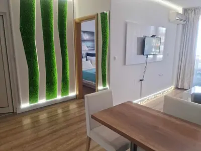 a living room with green walls and a table and a mirror at Aglaya 2 - Pomorie Bay in Pomorie