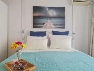 a bedroom with a bed with a vase of flowers on a table at Aglaya 2 - Pomorie Bay in Pomorie