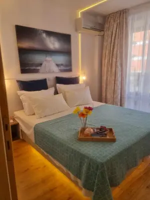 a bedroom with a bed with a tray with flowers on it at Aglaya 2 - Pomorie Bay in Pomorie