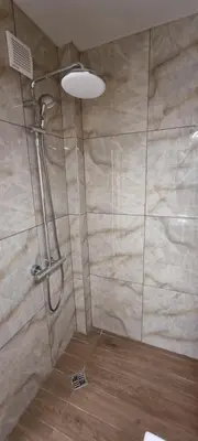 a shower with a shower head in a bathroom at Central Luxe Apartament Mimoza in Varna City