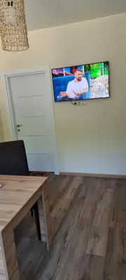 a living room with a tv on a wall at Central Luxe Apartament Mimoza in Varna City