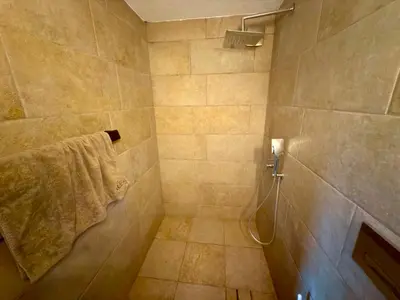 a bathroom with a shower with a towel at Arthotel Oscar II Sozopol in Sozopol