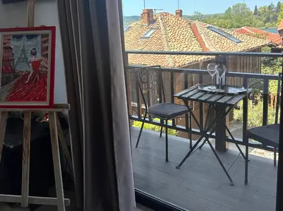 a balcony with a table and a view of a house at Arthotel Oscar II Sozopol in Sozopol