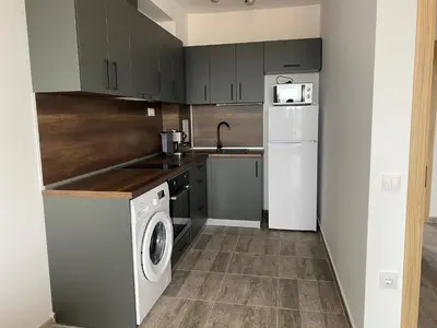 a kitchen with a washing machine and a washer at Vineyards Resort - Apartment Panorama in Kableshkovo