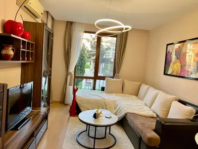 a living room with a couch and a tv at Prestige Fort Sveti Vlas Aparthotel 1 bedroom 4 people in Sveti Vlas