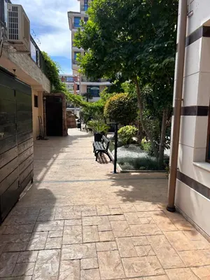 a walkway with benches and a tree and a building at Karolina Apartment 65 in Sunny Beach