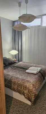 a bedroom with a bed with two towels on it at Апартамент ЛазуР in Burgas City
