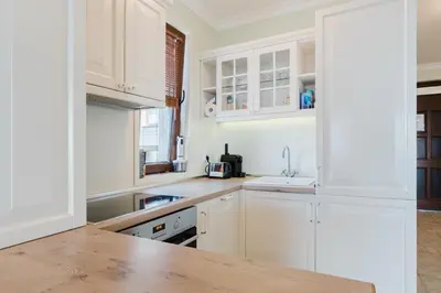 a kitchen with white cabinets and a wooden counter top at Sozopol Созопол MORE SUN 2 Б Sozopolis in Sozopol