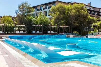 a swimming pool in a resort with a fountain at Двуспални апартаменти Оазис Бийч клуб in Lozenets