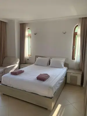 a bedroom with a large bed with two towels on it at Двуспални апартаменти Оазис Бийч клуб in Lozenets
