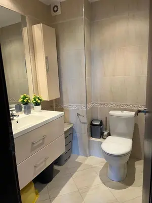 a bathroom with a toilet and a sink at Двуспални апартаменти Оазис Бийч клуб in Lozenets
