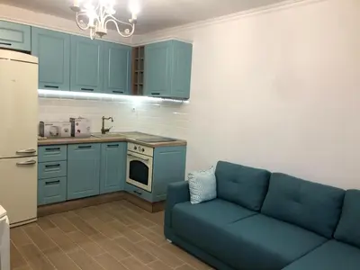 a kitchen with blue cabinets and a blue couch at Brandnew 3 Room Apartment with Poolview in Cascadas Resort in Sunny Beach
