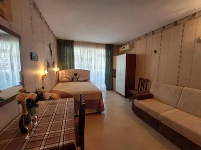 a bedroom with a bed and a couch at Студия в центре Солнечного берега in Sunny Beach