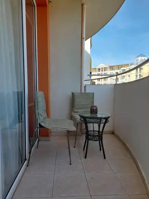 a small table and a chair on a balcony at Студия в центре Солнечного берега in Sunny Beach