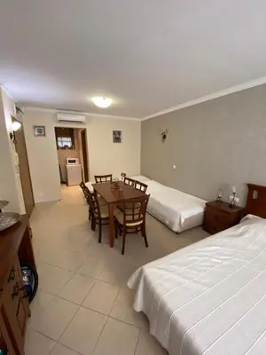 a hotel room with two beds and a table and chairs at Sozopol Santa Marina Sea View Studio in Sozopol