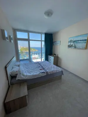 a bedroom with a bed and a large window at Апартамент Лариди in Sozopol