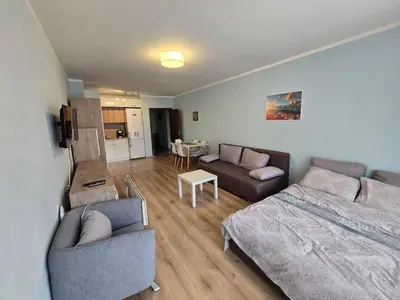 a living room with a bed and a couch at Апартамент ЛаХабана до плажа в Поморие in Pomorie