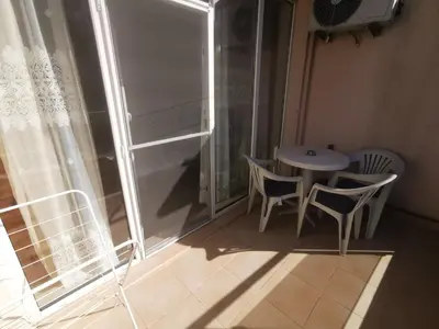 a room with a table and chairs and a window at Студиa Блу минута от плажа in Pomorie