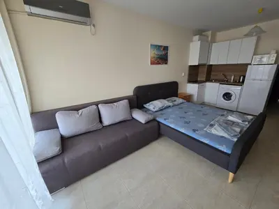 a living room with a couch and a kitchen at Студиa Блу минута от плажа in Pomorie