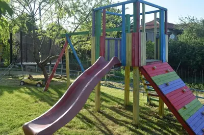 a playground with a slide in the grass at Къща Виктория in Banya