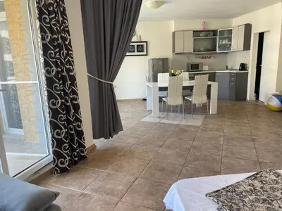 a living room with a table and a kitchen at Midia SP Apartments in Aheloy