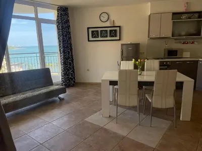 a kitchen and living room with a table and a couch at Midia SP Apartments in Aheloy
