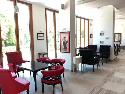 a waiting room with red chairs and tables and windows at Sunrise Luxury Sauth Bay in Varna City