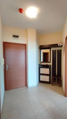 a hallway with a wooden door and a table in a room at Апартаменты с одной спальней Carolina in Sunny Beach