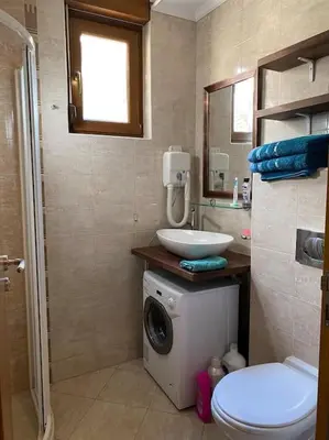 a bathroom with a washing machine and a sink at Santa Marina, Lovely 1-bedroom apartment in Sozopol