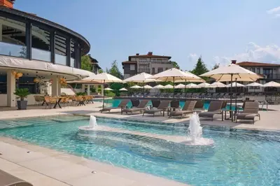 a pool with chairs and tables and umbrellas at Santa Marina, Lovely 1-bedroom apartment in Sozopol