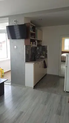 a kitchen with a refrigerator and a counter in a room at Къща за гости Ани in Chernomorets