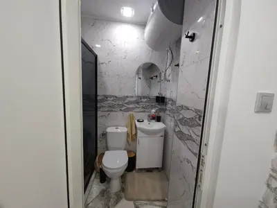 a bathroom with a toilet and a sink at Къща за гости Ани in Chernomorets
