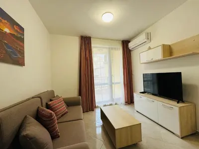 a living room with a couch and a flat screen tv at HORIZON 18 'Б' Apartment Sveti Vlas in Sveti Vlas