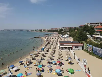 a beach with many umbrellas and people in the water at HORIZON 17 'Б' Apartment Sveti Vlas in Sveti Vlas