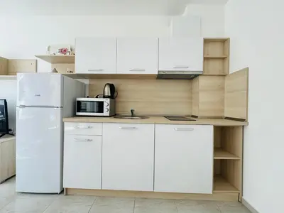 a kitchen with white cabinets and a white refrigerator at HORIZON 12 'Б' Apartment Sveti Vlas in Sveti Vlas