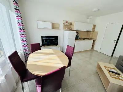 a kitchen and dining room with a wooden table and chairs at HORIZON 12 'Б' Apartment Sveti Vlas in Sveti Vlas