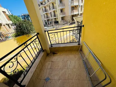 a balcony of a building with a yellow wall at HORIZON 12 'Б' Apartment Sveti Vlas in Sveti Vlas