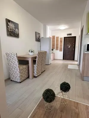 a living room with a table and chairs and a refrigerator at Апартамент 