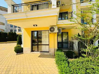 a yellow building with a balcony and a door at HORIZON 4 'Б' Apartment Sveti Vlas in Sveti Vlas