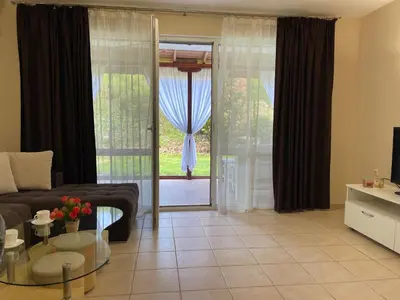 a living room with a couch and a sliding glass door at Sea Salt Suite- Sozopol in Sozopol
