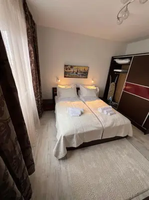 a bedroom with a large bed with white sheets at Tei-Zi apartments in Burgas City