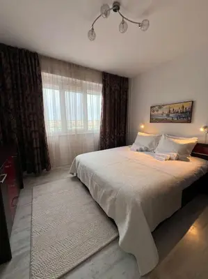 a bedroom with a large bed and a window at Tei-Zi apartments in Burgas City