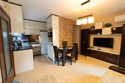 a kitchen and dining room with a table and chairs at Апартамент за гости Уют in Burgas City
