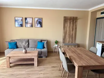 a living room with a table and a couch at Апартаменти Bella Deluxe in Ravda