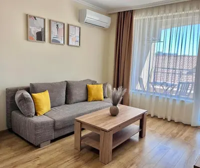 a living room with a couch and a table at Апартаменти Bella Deluxe in Ravda