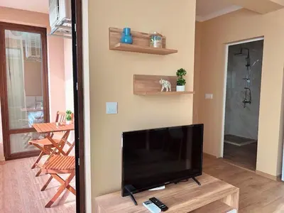 a living room with a flat screen tv on a table at Апартаменти Bella Deluxe in Ravda