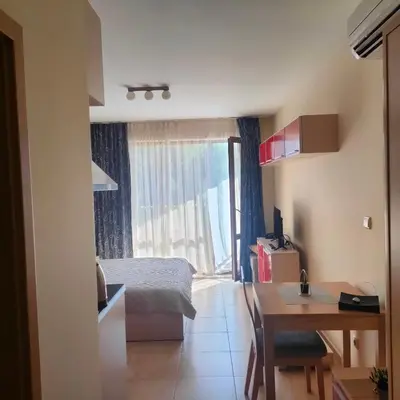 a bedroom with a bed and a desk and a table at Delta River Park in Sunny Beach
