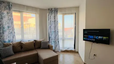 a living room with a couch and a large window at HORIZON 34 'В' Apartment Sveti Vlas in Sveti Vlas